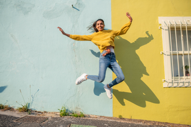 girl in yellow sweatshirt jumping