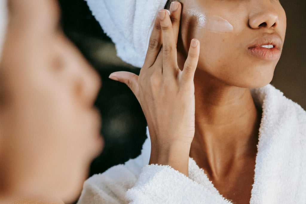 Woman applying skincare in the mirror